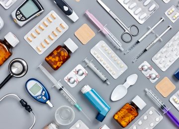 Directly above flat lay flat lay shot of various medical supplies. Full frame shot of medicines placed with syringes and diagnostic tools. All are on gray background.  Knolling concept.